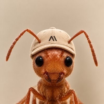 $ANT logo portrait: orange ant with an A-marked beige cap